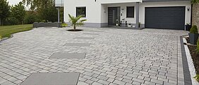 Das moderne Haus wird durch das Ökopflaster im Eingangsbereich und in der Einfahrt ergänzt. Durch den Farbverlauf entsteht eine lebendige Gestaltung im Außenbereich.